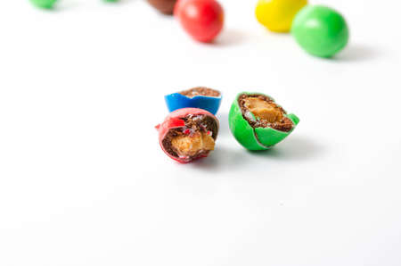 M & M's in packaging on a white background. Glazed nuts spilled out of the packaging on a white background cc close-up. M & M's on a white background balls top and bottom view. M & M's cutaway. July 2020. Kiev, Ukraineのeditorial素材