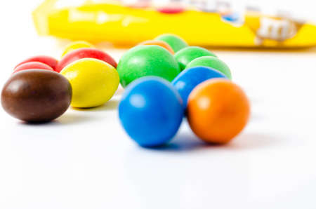 M & M's in packaging on a white background. Glazed nuts spilled out of the packaging on a white background cc close-up. M & M's on a white background balls top and bottom view. M & M's cutaway. July 2020. Kiev, Ukraineのeditorial素材