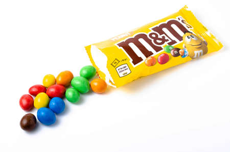 M & M's in packaging on a white background. Glazed nuts spilled out of the packaging on a white background cc close-up. M & M's on a white background balls top and bottom view. M & M's cutaway. July 2020. Kiev, Ukraineのeditorial素材