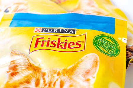 Friskies packing cat food on a white plate in close-up. Friskies logo. Many packs of cat food are piled up. July 2020. Kiev, Ukraineのeditorial素材