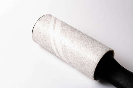 Roller for cleaning clothes on a white background in close-up. A flexible roller for cleaning clothes in a man's hand. Used, dirty clothes rollerの写真素材