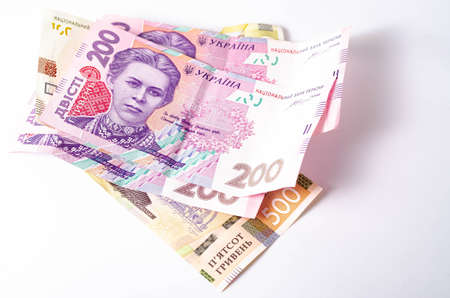 Banknotes Ukrainian hryvnia and dollars on a white background in close-up.の写真素材
