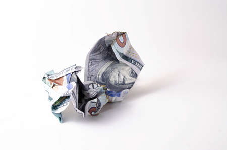 Crumpled, burnt dollar bills on a white background in close-up and in a man's handの写真素材
