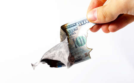 American dollars in a man's hand on a white background first-person view. Burnt dollars. Dollars are burning, Ashes, fireの写真素材