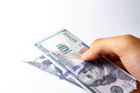 American dollars in a man's hand on a white background first-person view. Burnt dollars. Dollars are burning, Ashes, fireの写真素材