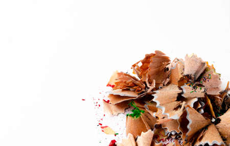 Shavings of red pencil in close-up on a white background. Pencil lead whole and broken on a white background. Leftovers from a pencil. Macro, a pile of shavingsの写真素材