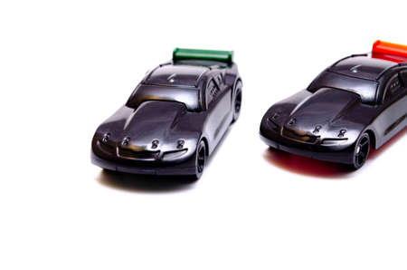 Two sports toy cars on a white background in black with a green and red wing in close-upの写真素材