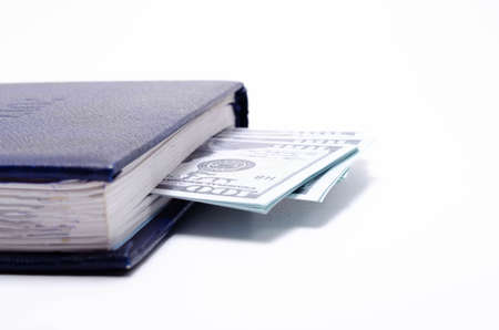 100 dollar bills lie in a blue notebook on a white background in close-up. A man's hand opens a...