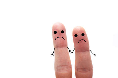 Two fingers on a white background with and without a face. Various emotions, joy, sadness, anger are depicted on the fingersの写真素材