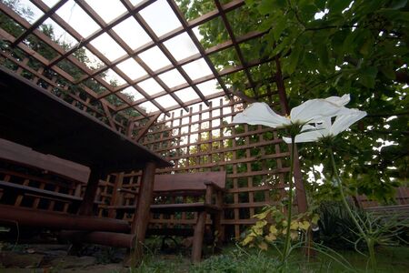 Wooden garden furniture standing in the gazebo with airy wallsの写真素材