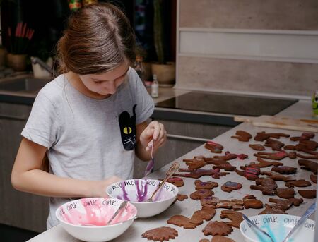 girl decorates gingerbread, traditional Christmas cakesの写真素材