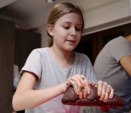 girl helps to make a dough for a traditional Christmas dishの写真素材