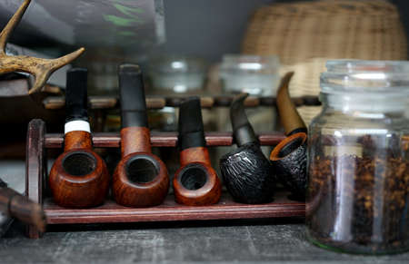 a collection of old briar pipes for smoking on a standの写真素材