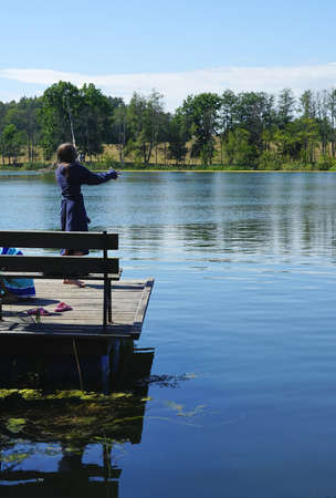 girl on the pier goes fishing with spinningの写真素材
