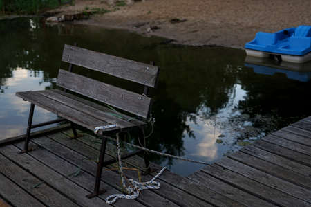 wooden bench on the pier on the lakeの写真素材