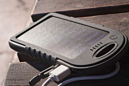 solar powered power bank on wooden table in the sunの写真素材