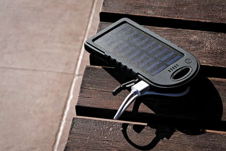solar powered power bank on wooden table in the sunの写真素材