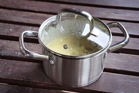 metal pot on a wooden garden tableの写真素材