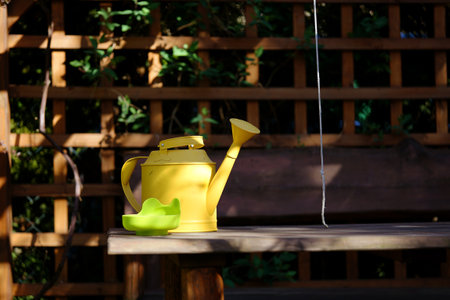 a yellow metal watering can on the table in the garden gazeboの写真素材