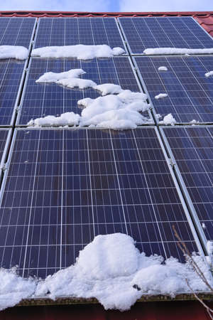 solar panels partially covered with snowの写真素材