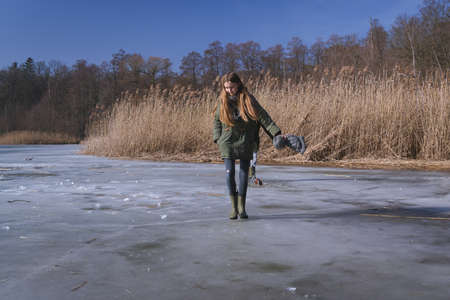 a girl with long hair walking on the ice of the lakeの写真素材