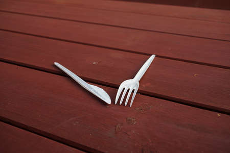 Plastic disposable cutlery on a wooden tableの写真素材