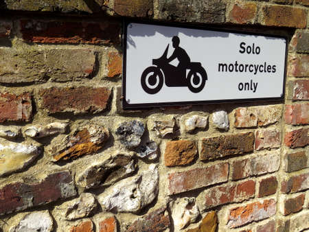 solo motorcycles only sign on a brick and flint stone wallの写真素材