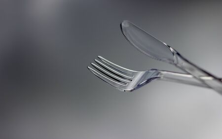 A Plastic Transparent Knife and Fork with a Sky Backgroundの写真素材