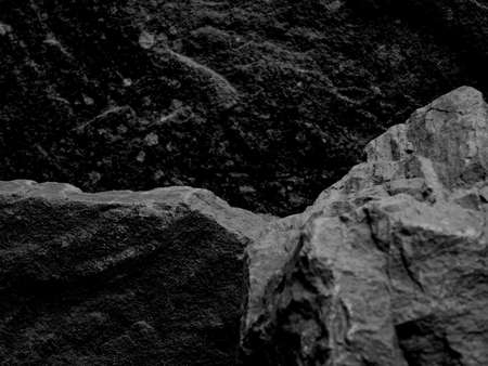 A Rough Textured Rock with Middle Focus for a Product Display Shelf, with a Stone Blurred Black and White Backgroundの写真素材