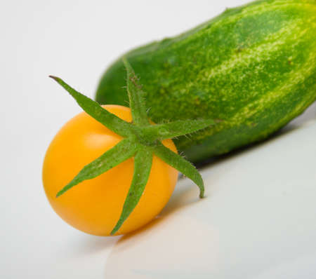 green cucumbers and yellow tomatoesの写真素材