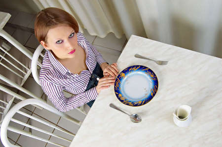 A hungry girl with an empty plate. It limits herself to the food.の写真素材