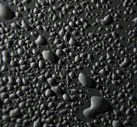 water drops on white surface with a hard side lightの写真素材