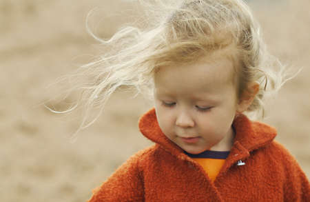 Portrait of a little girl. The wind blows her long thin hair. Shallow DOF.の写真素材