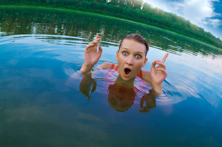 beautiful young girl with a bright emotions swimming in the riverの写真素材