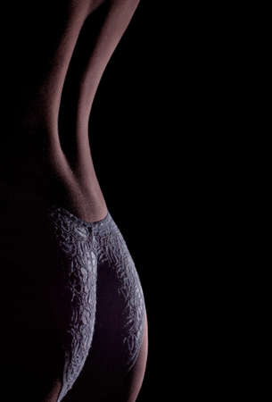 Buttocks and back are a beautiful woman on a black background. Beautiful backdrop to the theme of erotic fantasies.の写真素材