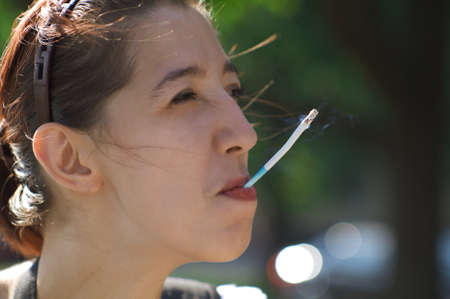 Smoking girl as a symbol of the antithesis of beauty. The photograph on the theme of social advertising.の写真素材