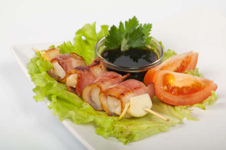 Japanese yakitori with the heart and bacon on a white plateの写真素材