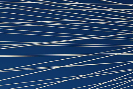 Steel white ropes against the blue sky, close-up, abstraction. Engineering constructions of the...