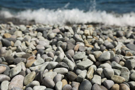 Pebble stones and with tidal bore of sea on backgroundの写真素材