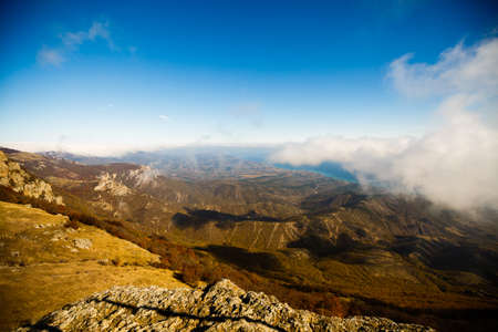 Autumn scenery of yellow and orange mountain ridges and hills photographed from the summit above...