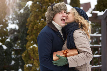 Man is hides box behind his back and going to give his woman a present on Valentines Day, Christmas...