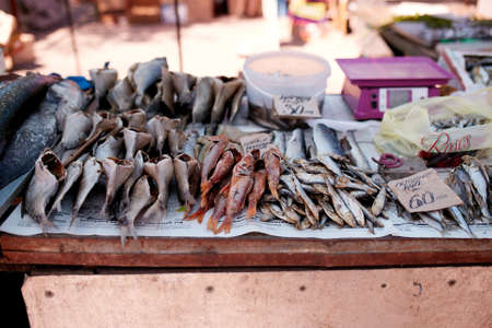 Dried fish on rope at stall on summer market for sale. Salted local seafood. Fishing concept.の写真素材