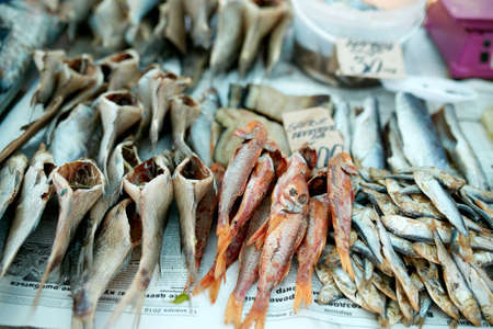Dried fish on rope at stall on summer market for sale. Salted local seafood. Fishing concept.の写真素材