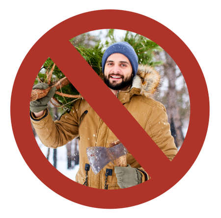 Crossed out red sign on bearded lumberjack man carrying freshly cut down christmas fir tree and axe in woods. Deforestation ban. Irresponsible behavior towards nature, save forest, keep green concept.の写真素材