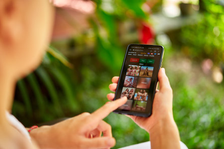 February 5, 2023, Mirissa, Sri Lanka. Using Pornpen website on phone. Woman testing artificial intelligence erotic image generator. Person creating nudity pictures via neural network online close-up.のeditorial素材