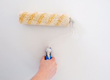 white paint roller on wall (painting wall)の写真素材