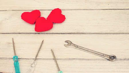 Vintage love repair,Red Heart and a screwdriver on the woodの写真素材