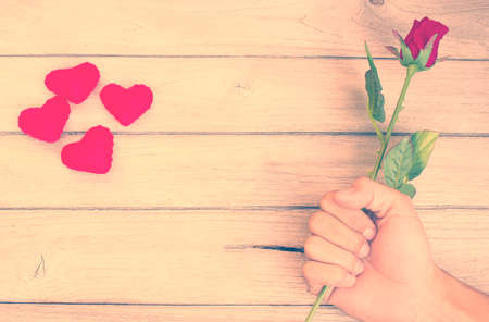 vintage The feeling of love,Rose in hand on woodの写真素材