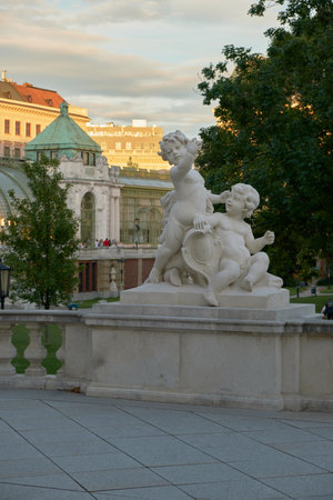 Sculpture of two infant cherubs in Vienna's Palm House garden, highlighting detailed craftsmanship, classical design, and serene outdoor ambiance.の写真素材