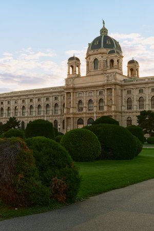 View of Vienna's Natural History Museum with a beautifully manicured garden featuring neatly trimmed shrubs in the foreground, highlighting classical architecture.の写真素材